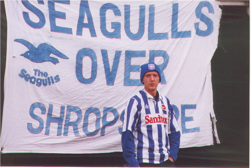 Young Fan stands in front of Seagulls over Shropshire Flag, Cheltenham Town game 25 September 1999